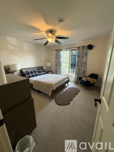 A bedroom with a bed, dresser, and window.