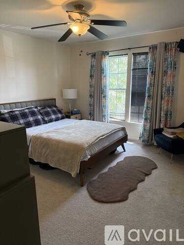 A bedroom with a large bed and a ceiling fan.