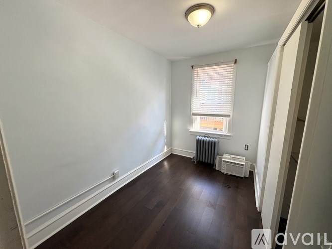 A bathroom with a marble wall and a glass shower stall.