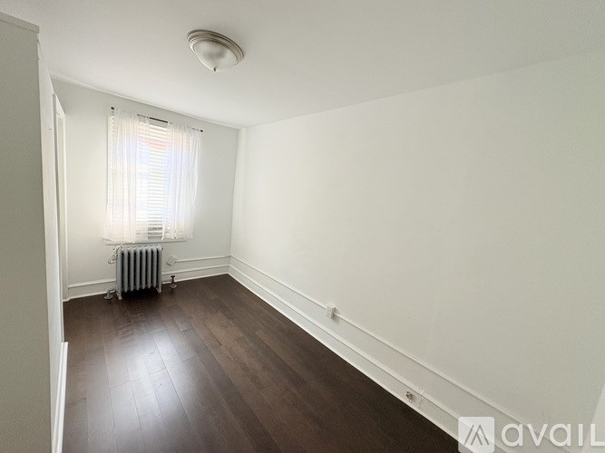 A room with a white tiled floor and a staircase on the left side.