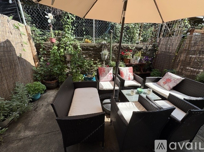 A patio with a table and chairs under an umbrella.