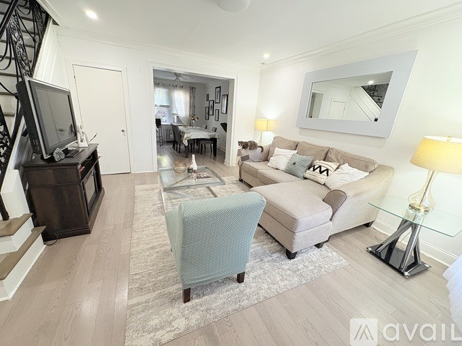 A living room with a grey sofa, a blue chair, and a television.