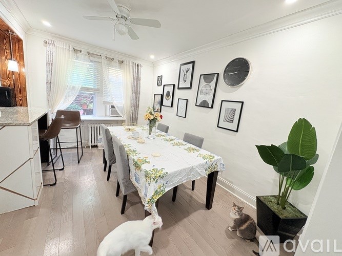 A dining room with a table set for a meal and a cat sitting on the floor.