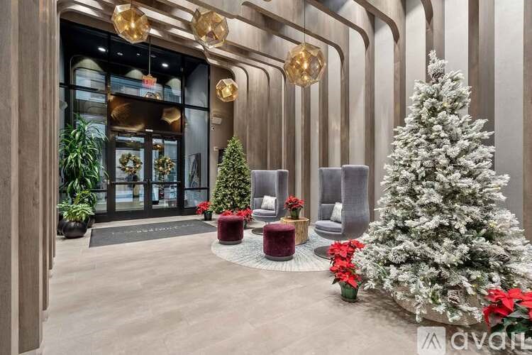 A large, snowy Christmas tree sits in the middle of a room with a modern design.
