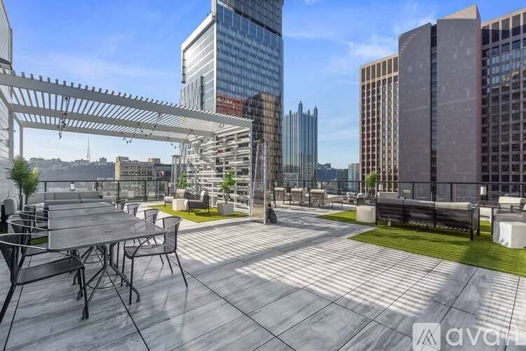 A rooftop patio with a table and chairs overlooking a city skyline.