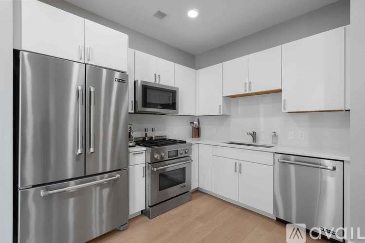 A modern kitchen with stainless steel appliances and white cabinets.