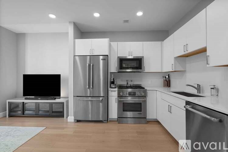 A modern kitchen with stainless steel appliances and white cabinets.