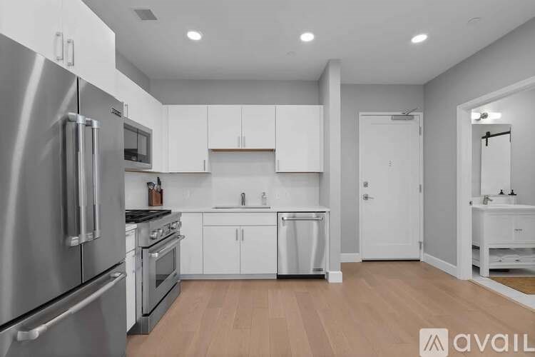 A modern kitchen with stainless steel appliances and white cabinetry.