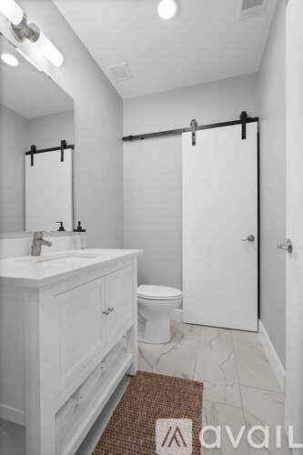 A white bathroom with a sink, toilet and shower.