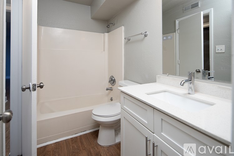 A white bathroom with a toilet, sink, and bathtub.