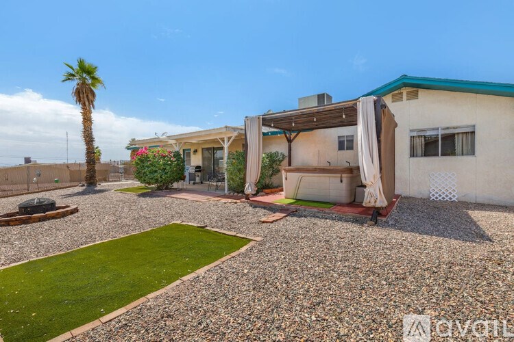 A house with a gravel driveway and a palm tree in the yard.