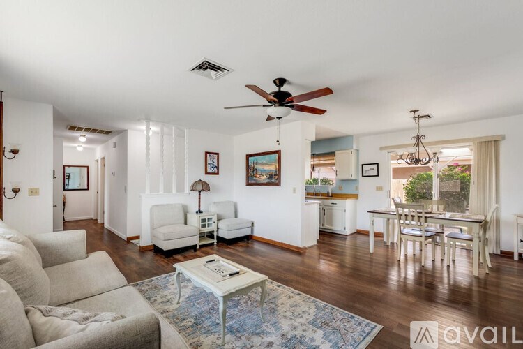 A living room with a white couch and a blue rug.