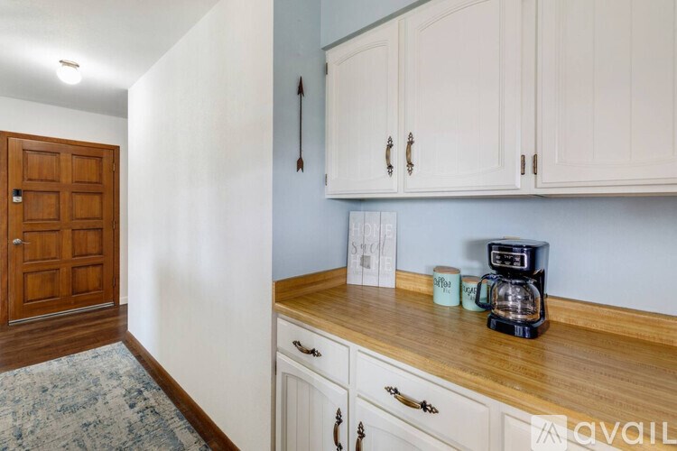 A kitchen with white cabinets and a wooden countertop.