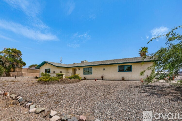 A house with a gravel driveway in front of it.