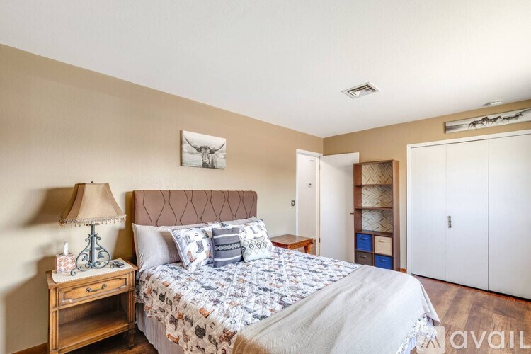 A bedroom with a bed, nightstand, and lamp.