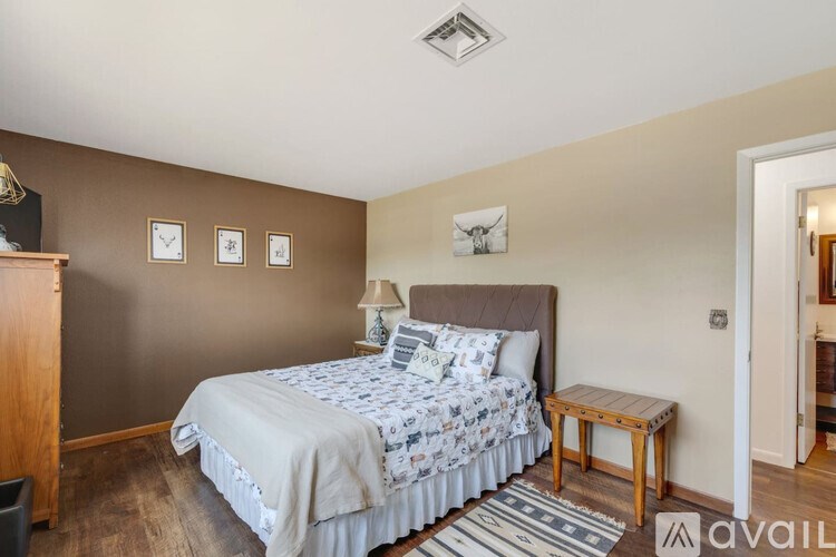 A bedroom with a bed, nightstand, and a lamp.