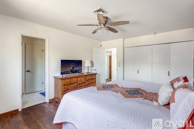 A bedroom with a large bed and a ceiling fan.