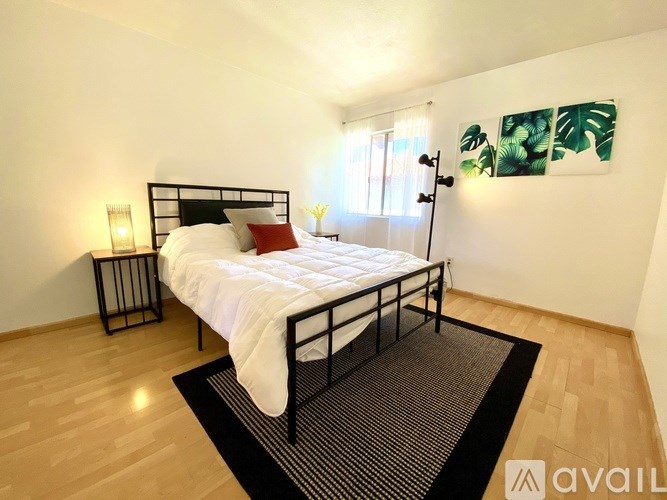 A bedroom with a bed, nightstands, and a rug.