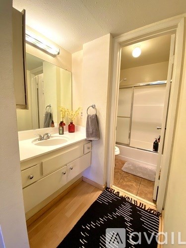A bathroom with a sink, mirror, and towel rack.