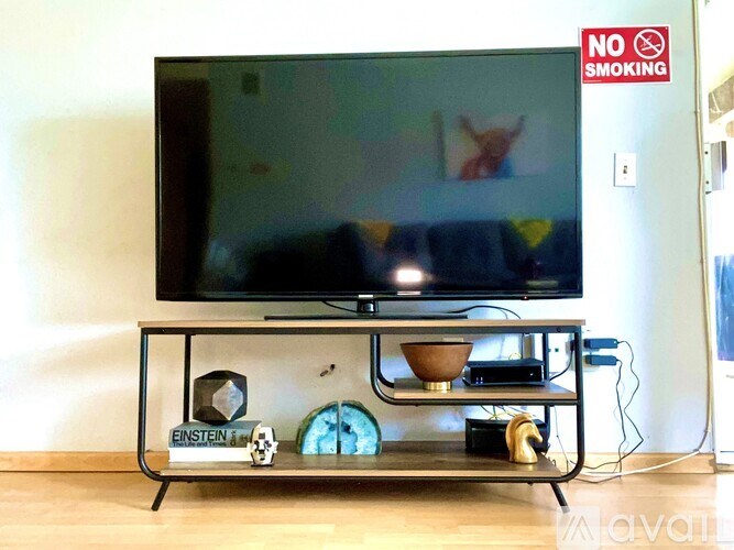 A black television set on a glass stand with a sign that says no smoking.