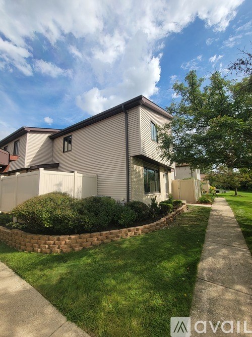 A house with a white fence and a well-kept lawn.