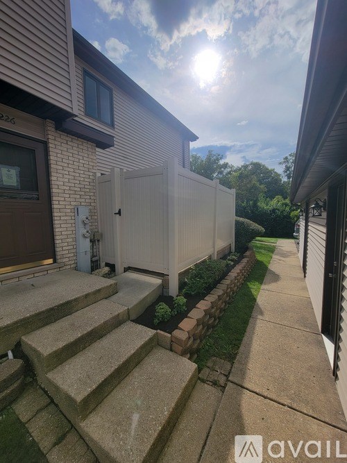 A house with a brown door and a white fence.