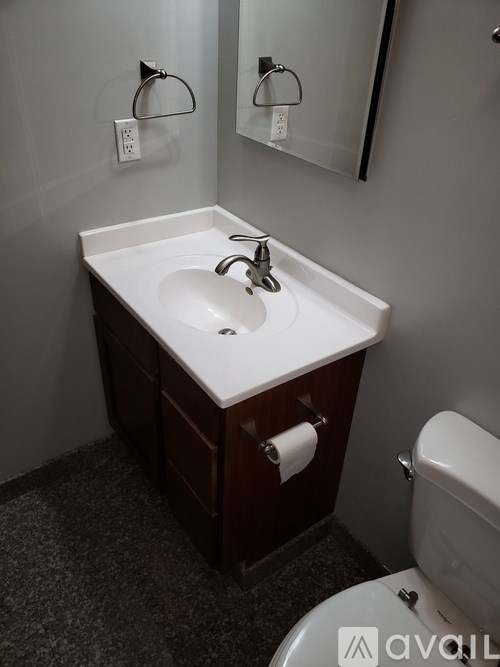 A bathroom with a sink, toilet and mirror.