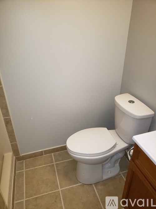 A white toilet with a white tank is in a bathroom with beige tiles.