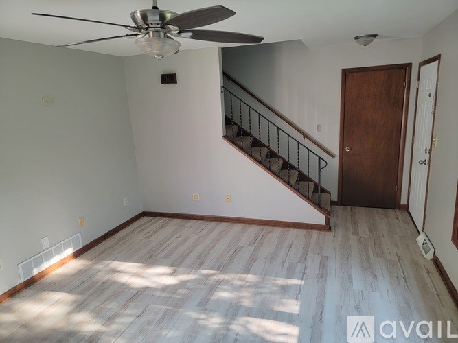 A room with a wooden floor and a ceiling fan.