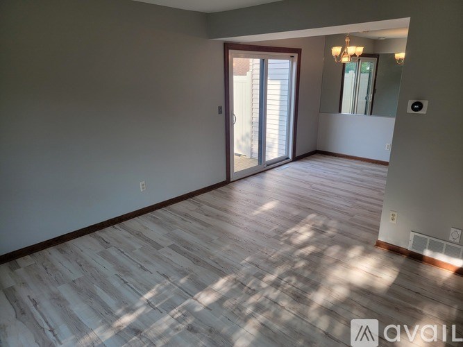 A room with wooden flooring and a sliding glass door.