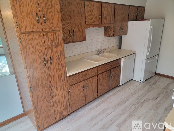 A kitchen with wooden cabinets and a white fridge.