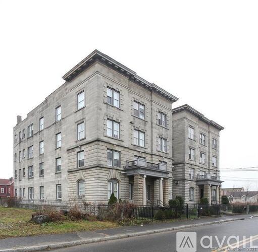 A large, old building with many windows and a balcony on the second floor.