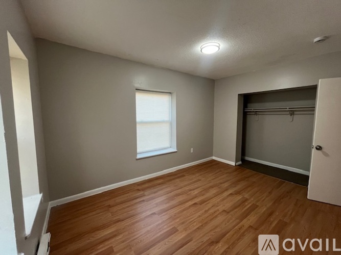 A room with wooden flooring and a window.