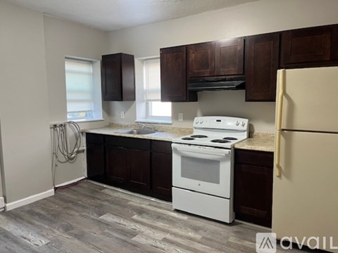A kitchen with a white stove and brown cabinets.