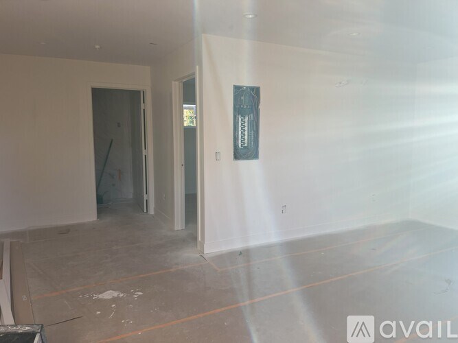 A room with a doorway leading to another room and a sign on the wall.