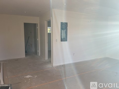 A room with a doorway leading to another room and a sign on the wall.
