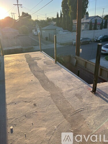 A skate park with a ramp and a few cars parked in the background.