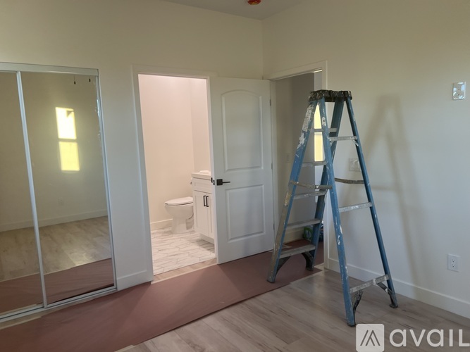 A room with white walls and a door is under construction.