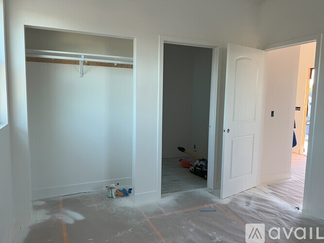 A room with white walls and a door is under construction.