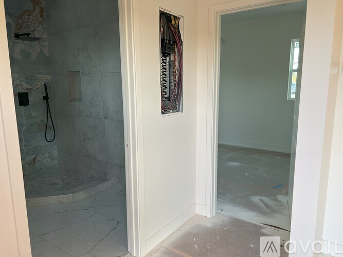 A bathroom with a glass shower door and a white door.