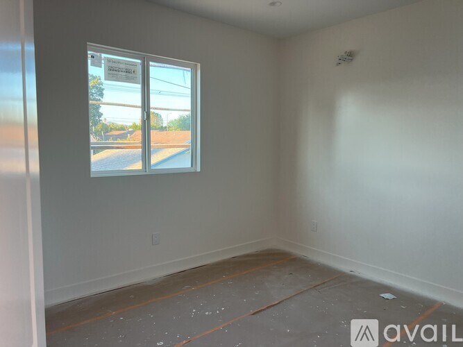 A room with a window showing a street view and a sign that says "AVAILABLE".