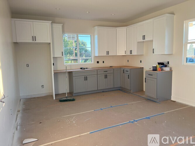 A kitchen under construction with cabinets and appliances in place.