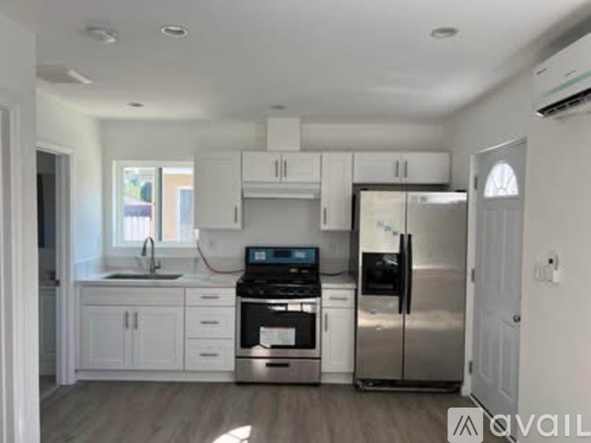 A kitchen with white cabinets and stainless steel appliances.