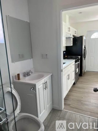 A bathroom with a toilet, sink, and mirror.