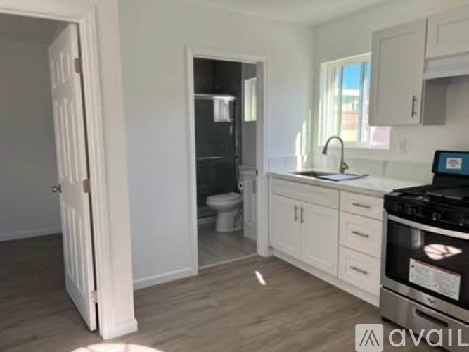 A kitchen with white cabinets and a black stove top oven.