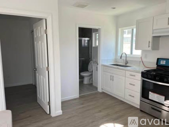 A kitchen with white cabinets and a black stove top oven.