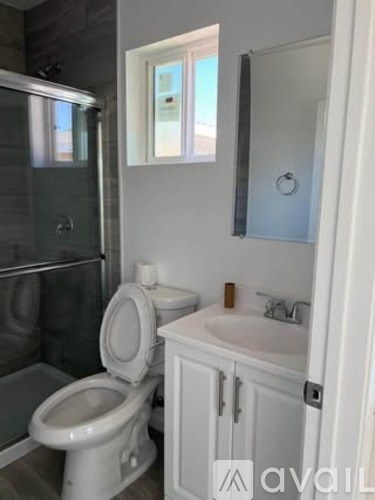 A white toilet sits next to a sink in a bathroom.