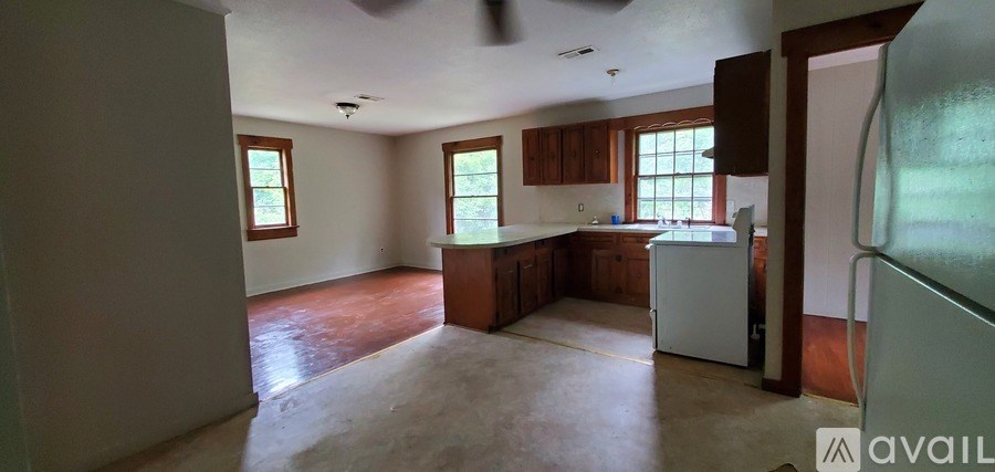 A kitchen with brown cabinets and a white refrigerator.