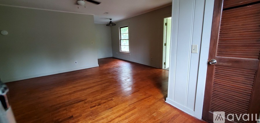 A room with wooden floors and a ceiling fan.