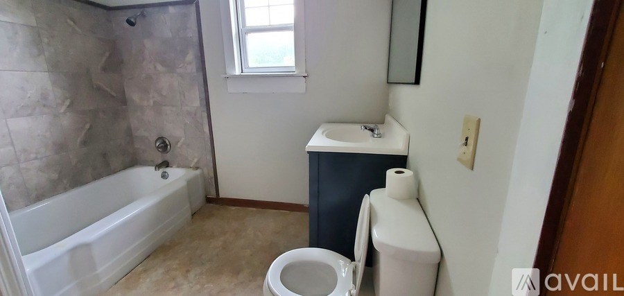 A bathroom with a toilet, sink, and bathtub.